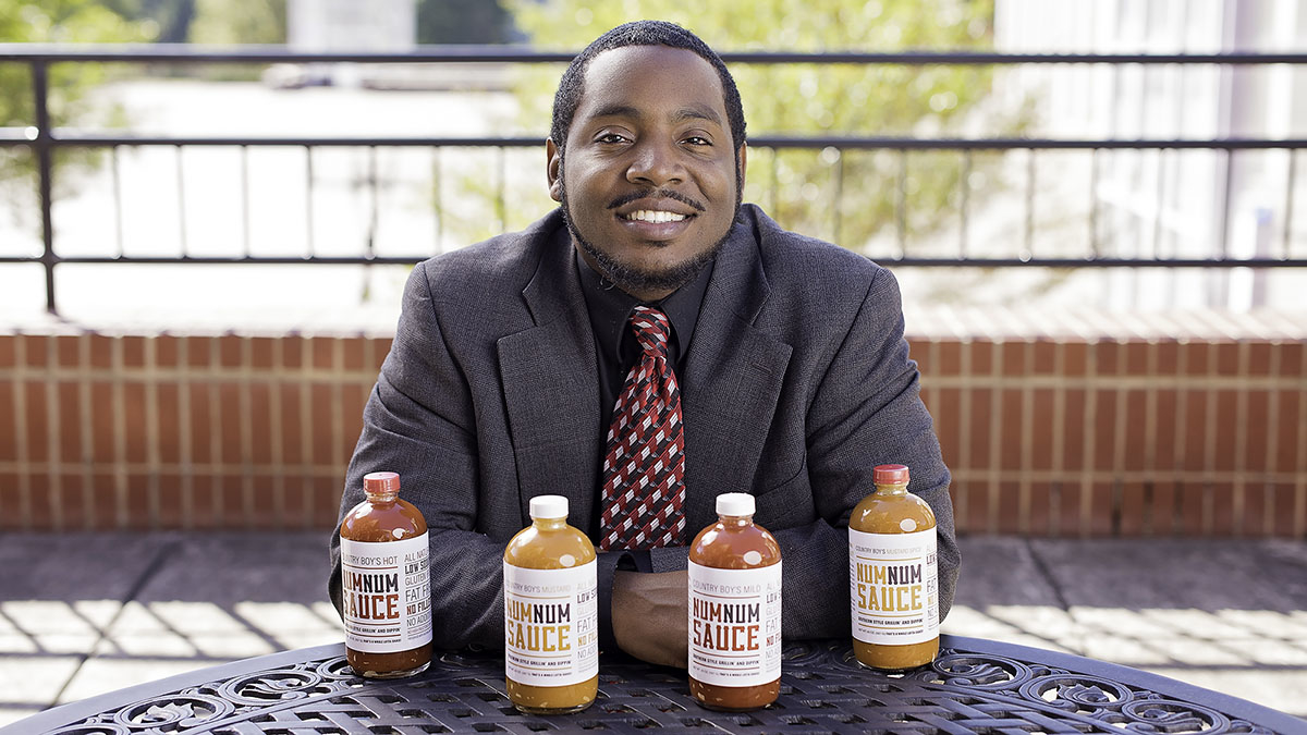 Michael Lloyd, a PhD student at NC State smiling with his self-made sauce