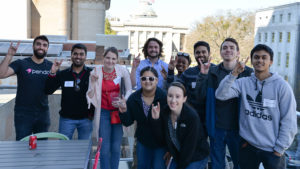 NC State entrepreneurship students pose with wolf sign in downtown Raleigh.