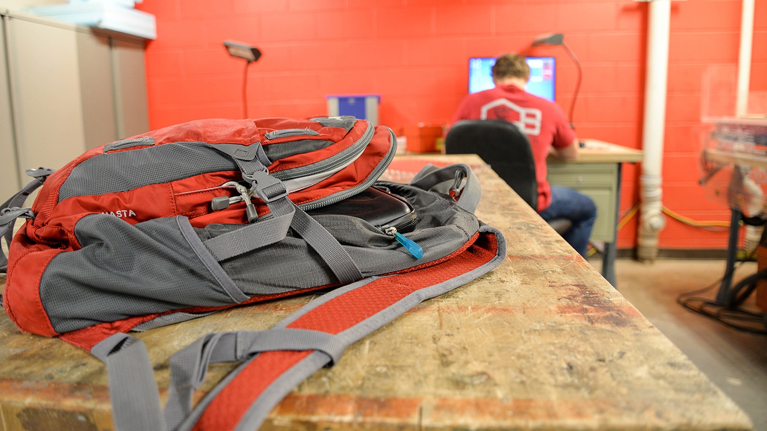 A red backpack sits on the desk in the NC State eGarage workshop.