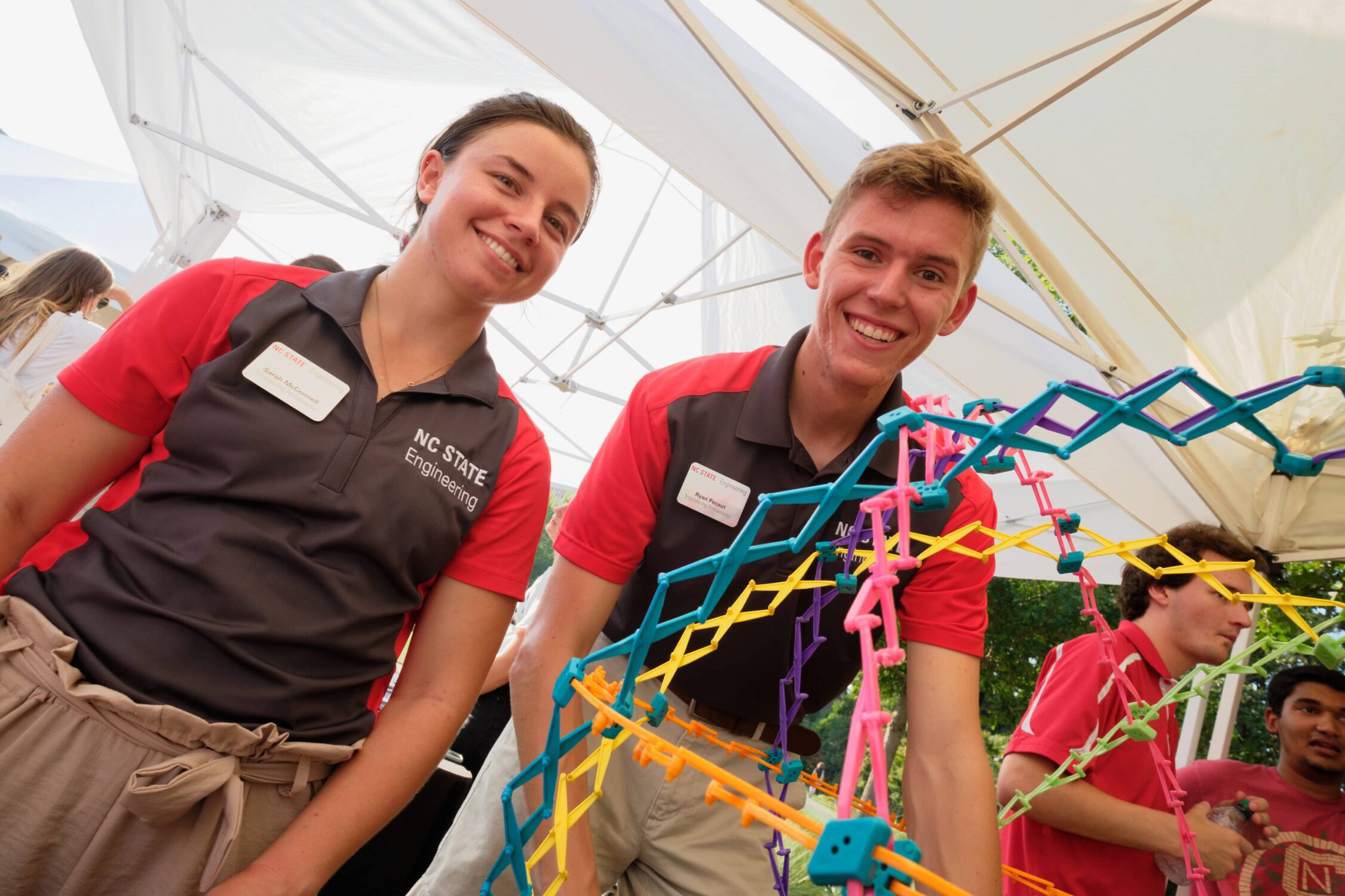 engineering students smiling with colorful structure model