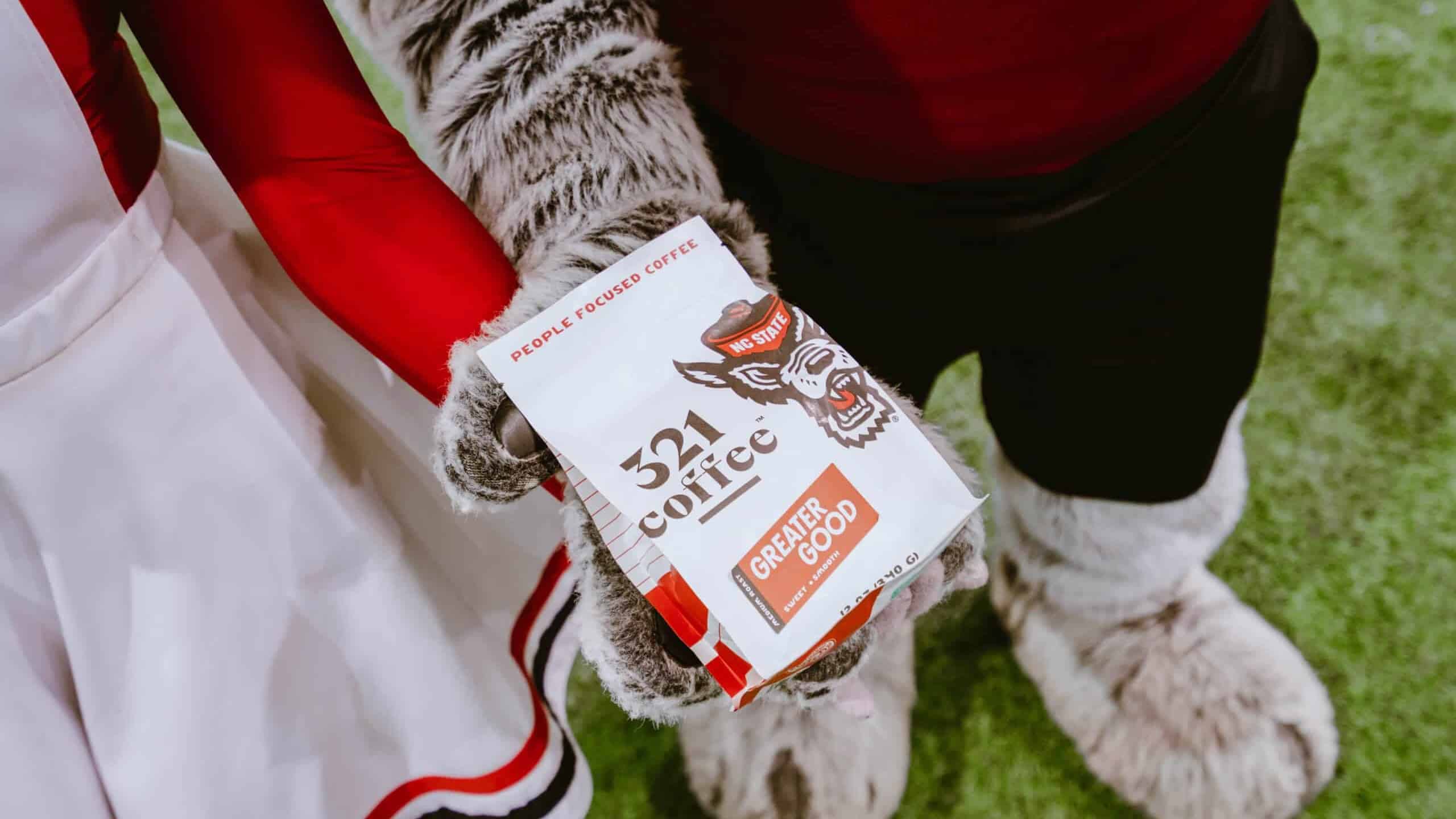 Mr. and Mrs. Wuf holding the NC State x 321 branded coffee