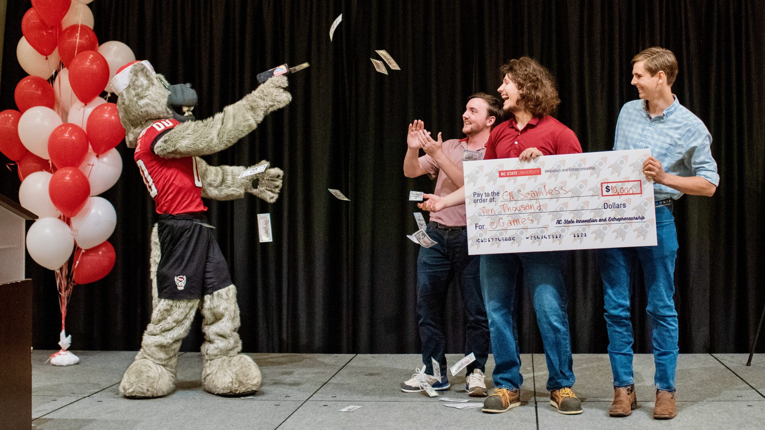 Mr. Wuf shoots a cash cannon over the CN Seamless team as they accept their check on stage