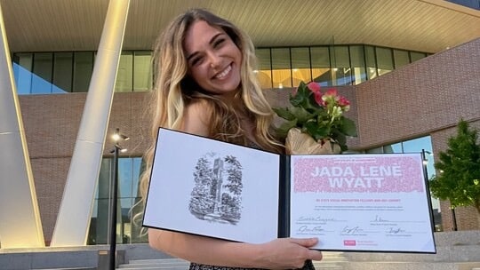 Jada Wyatt smiles and holds a certificate