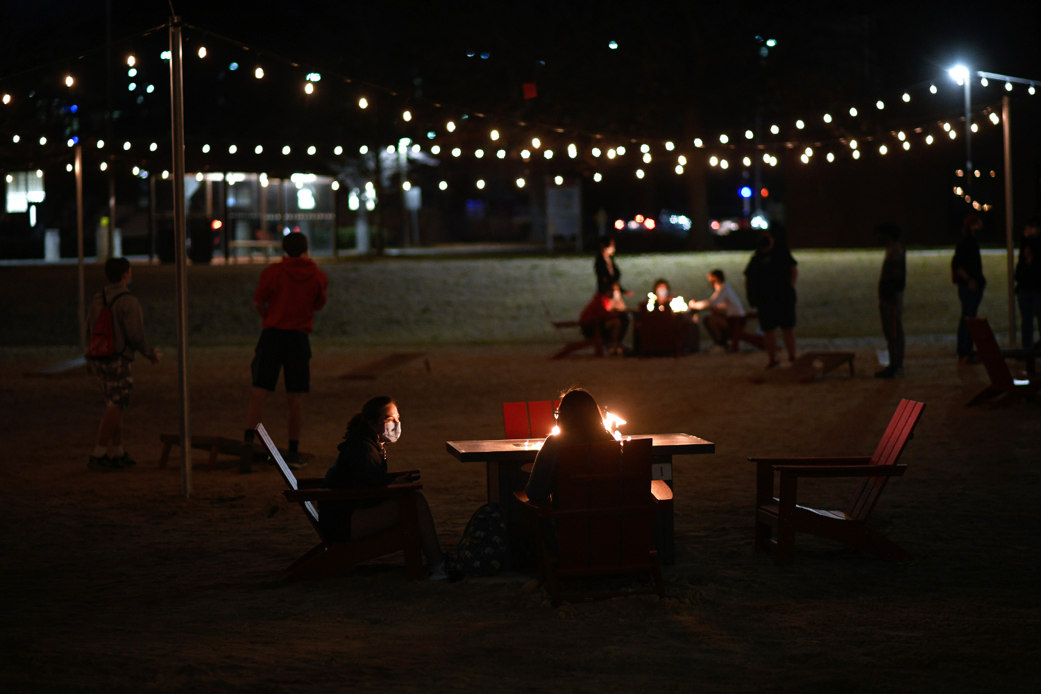 Two students sitting a fire pit