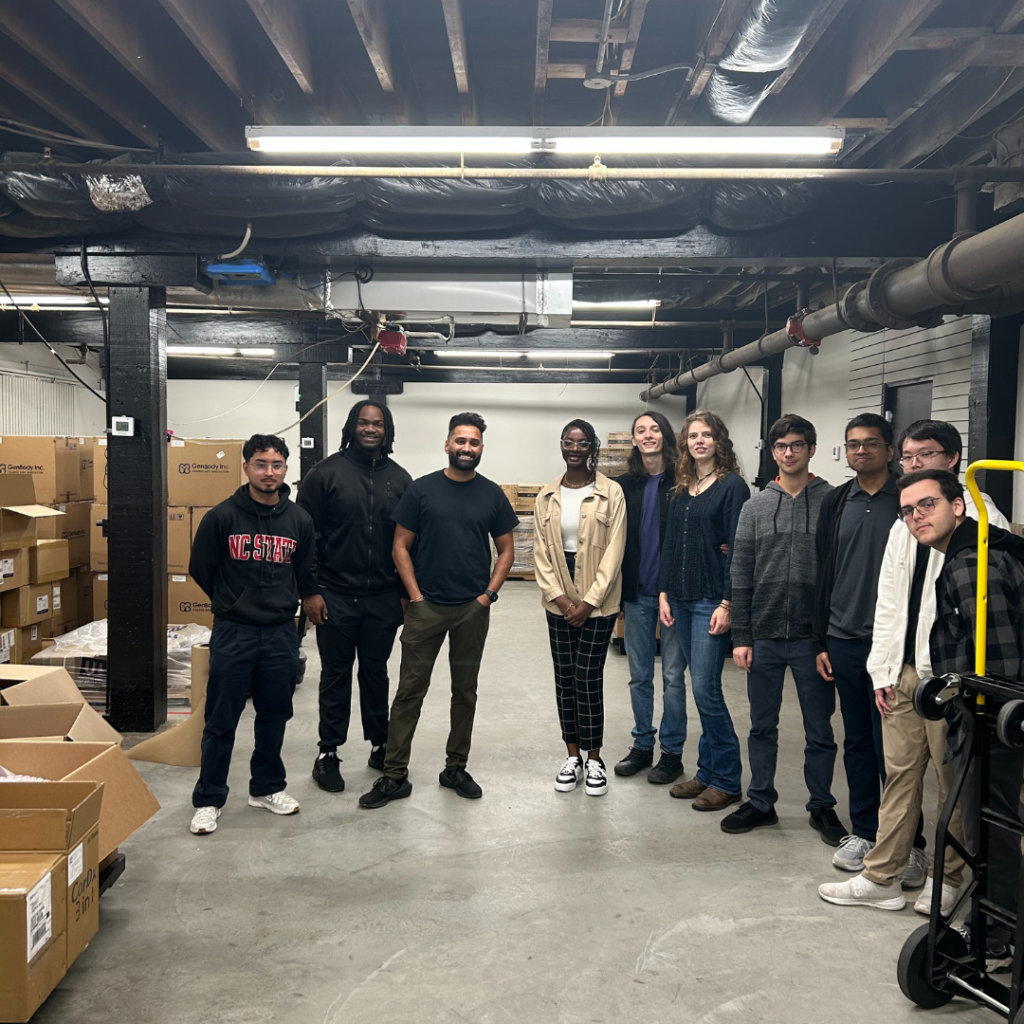 Students posing for a picture in a warehouse.