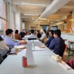 Group of students sitting and talking with a business owner