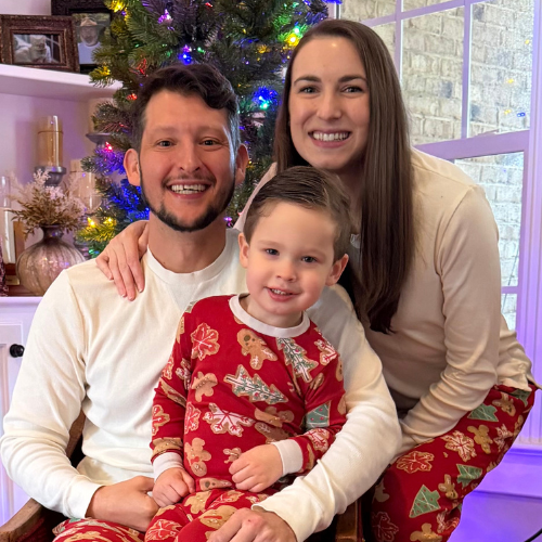 A family in front of a Christmas tree.